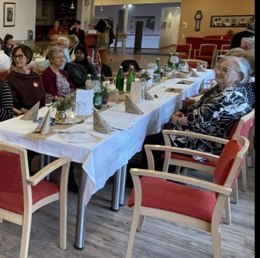 Einige Personen bei Tisch.