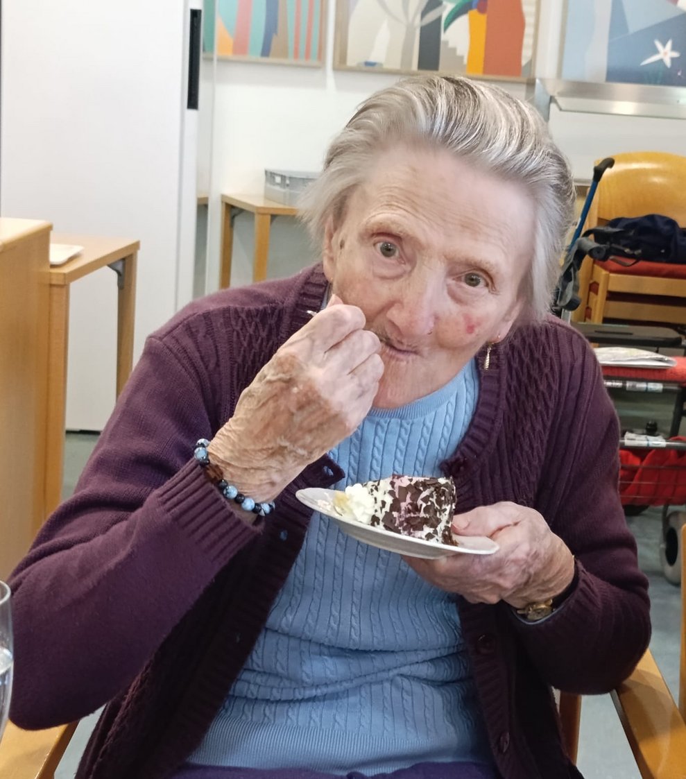 Bewohnerin beim Tortenstück essen.