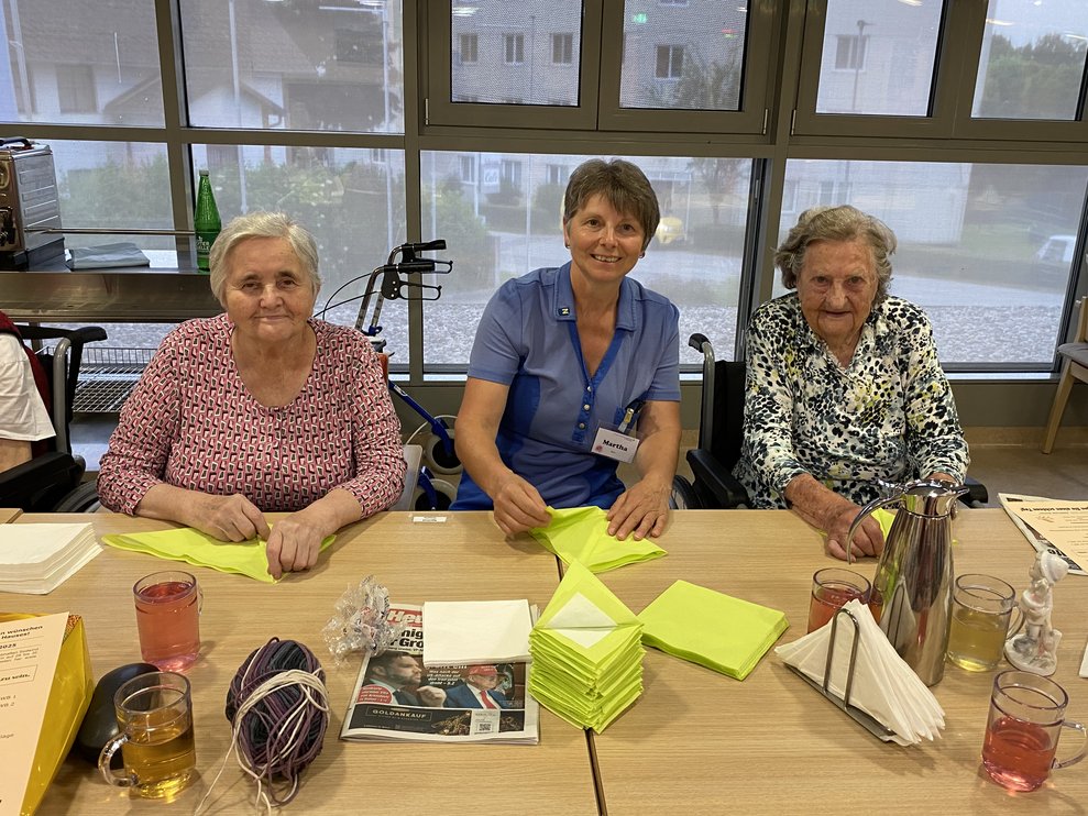 MEA Martha faltet gemeinsam mit Frau Sprinzl und Frau Breinhölder.