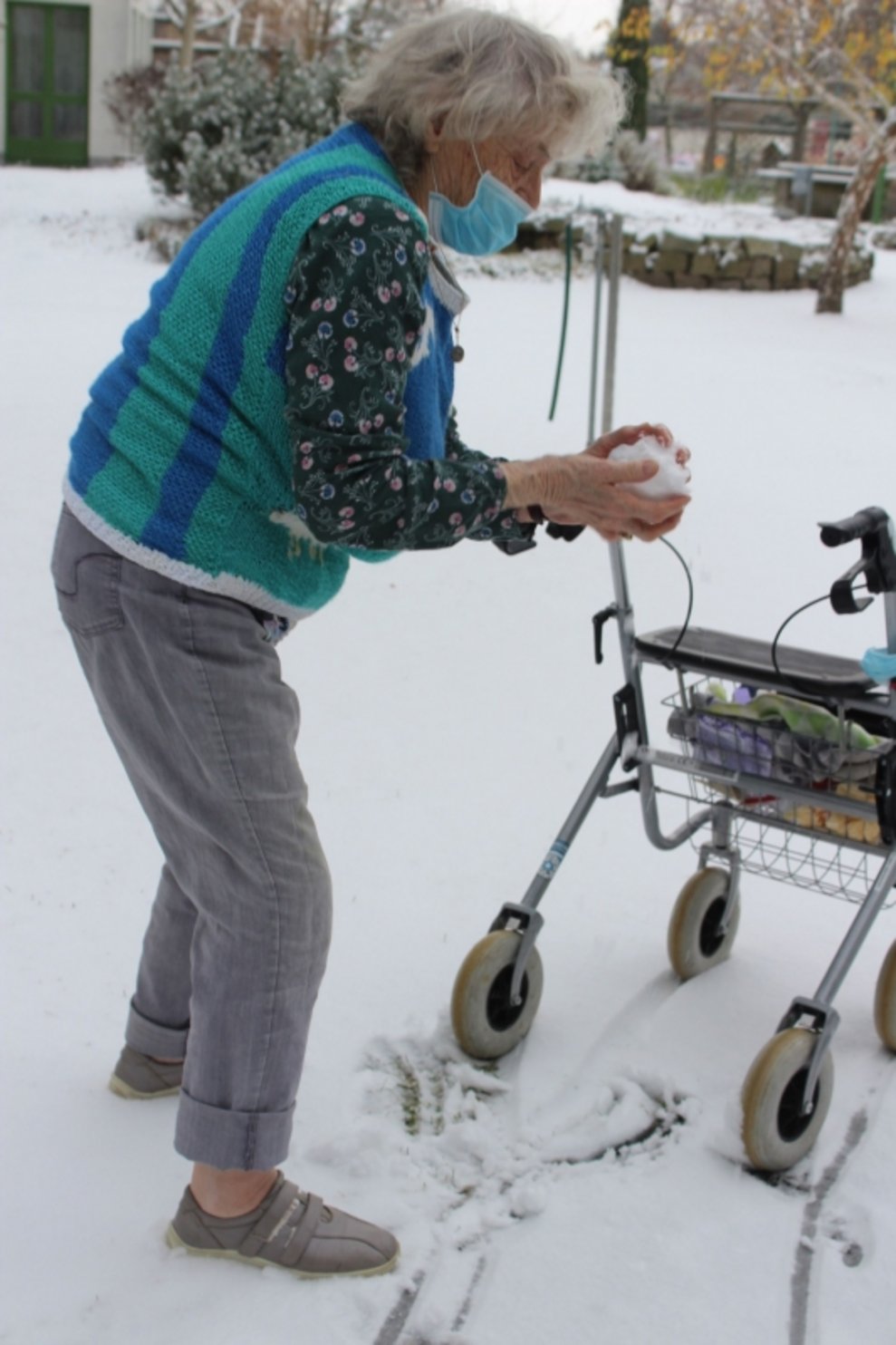 Eine Bewohnerin formt einen Schneeball.