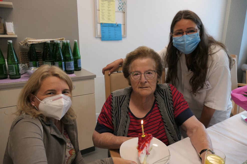 Drei Frauen mit einem Stück Torte.
