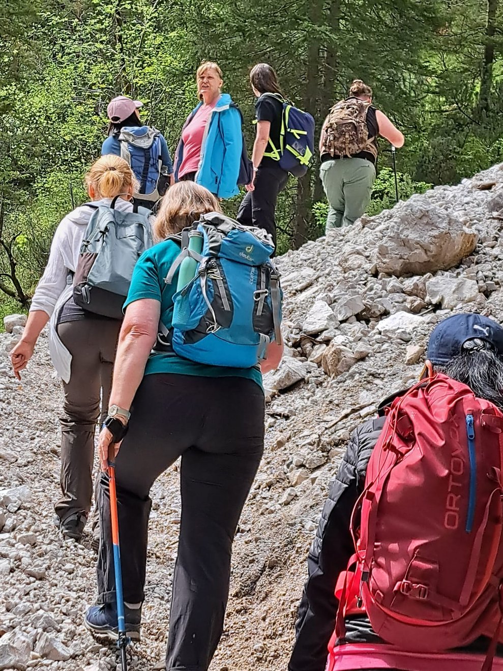 8 Personen gehen hintereinander bergauf.