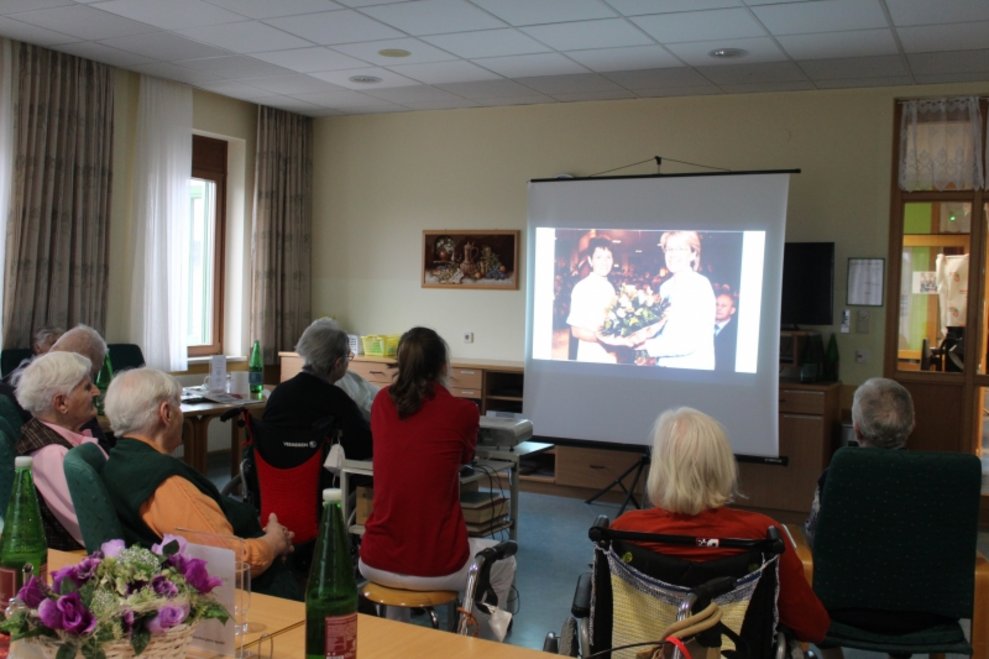 BewohnerInnen schauen sich eine PowerPoint-Präsentation an.