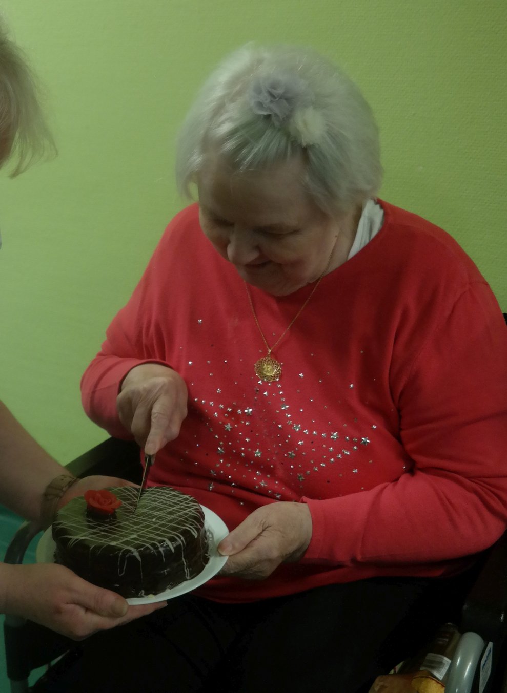 Eine Bewohnerin schneidet Torte.