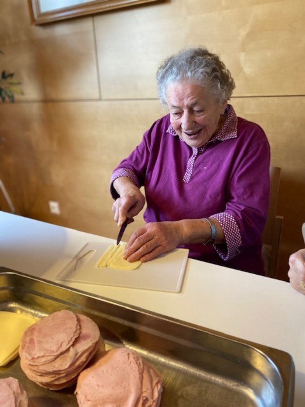 Bewohnerin schneidet Käse in Stücke
