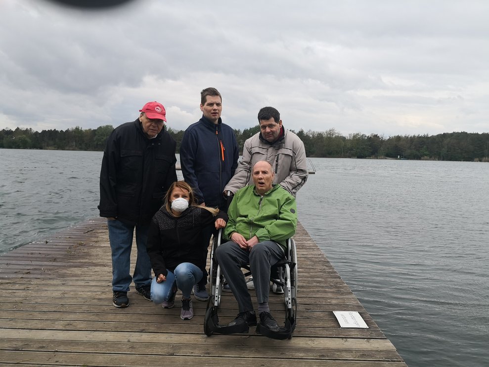 Personen stehen bei einem See