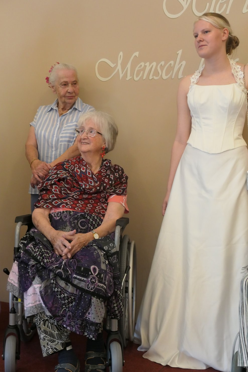 Unsere Praktikantin im Brautkleid mit 2 Bewohnerinnen auf dem Laufsteg.
