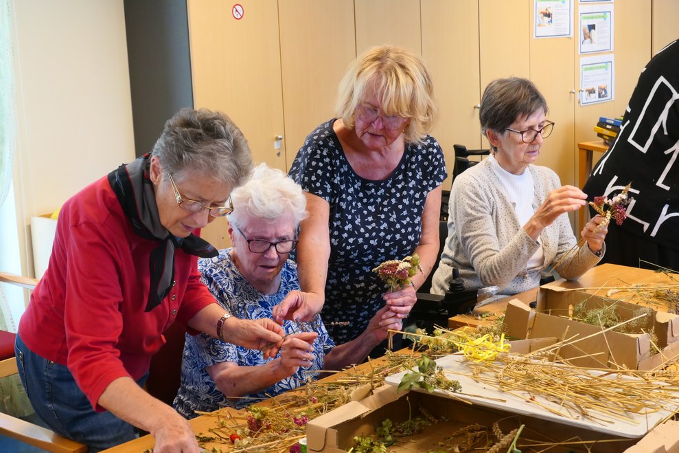 Vier Damen binden Erntedanksträußchen.