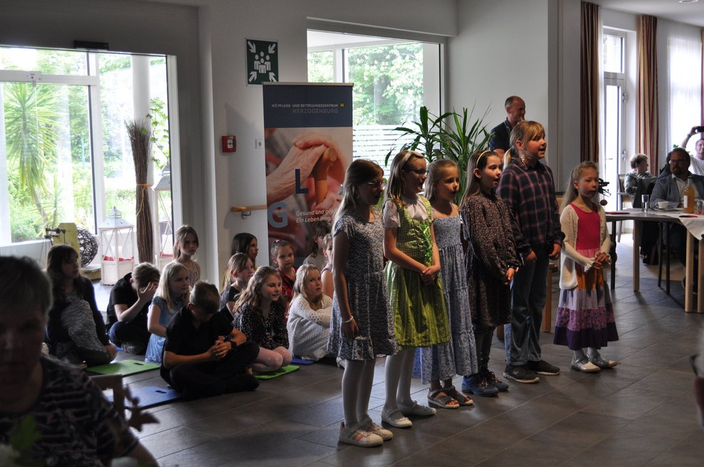 einige Kinder singen vor den Bewohnerinnen und Bewohner 