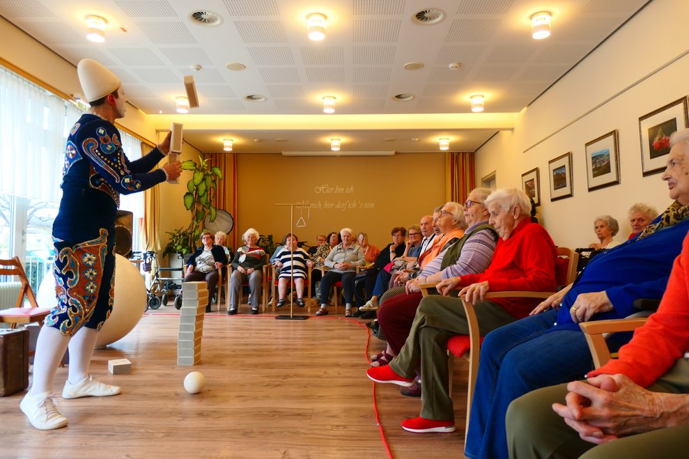 Der Weißclown balanciert Holzblöcke.