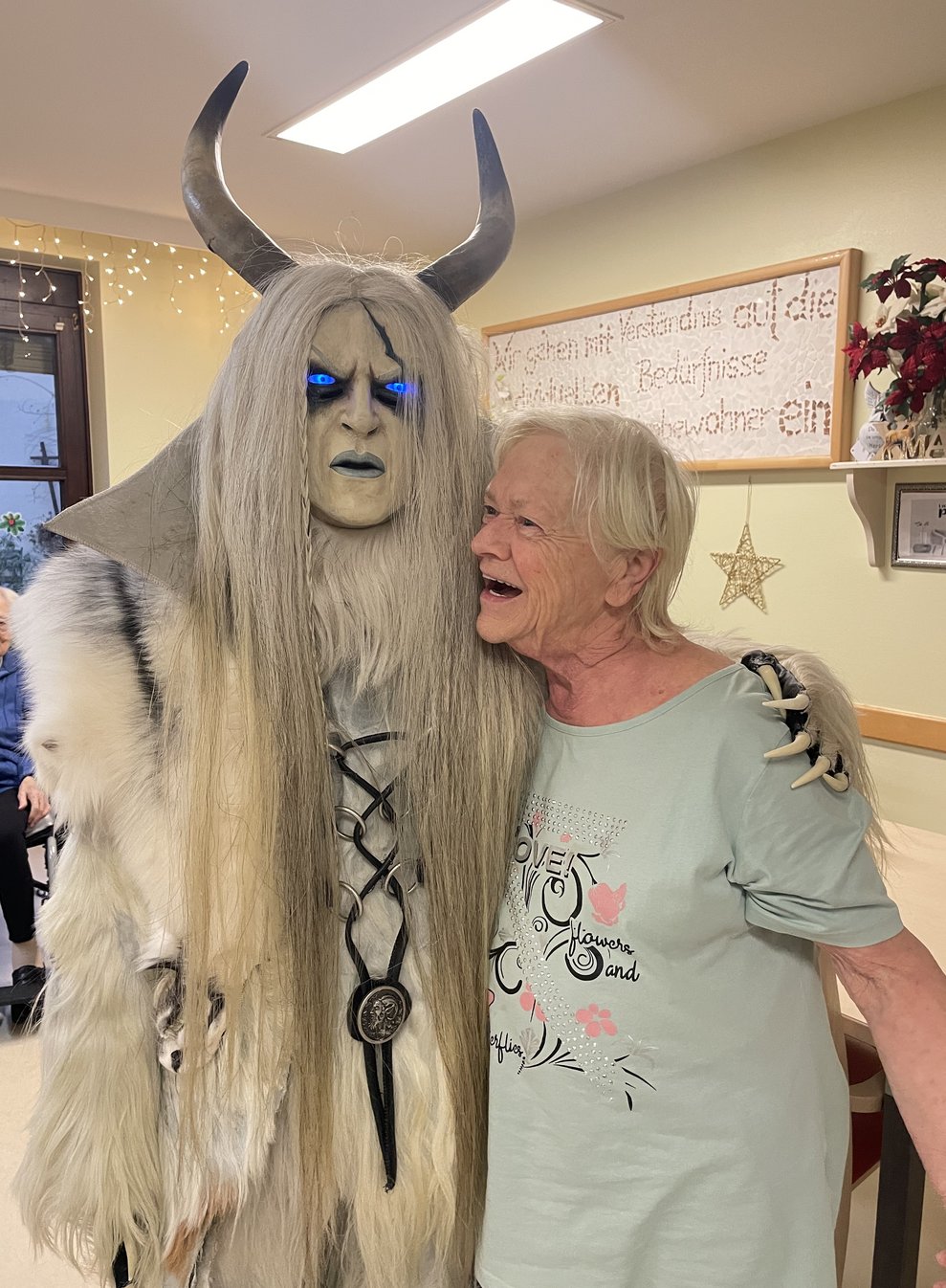 Eine Frau umarmt den Krampus. 