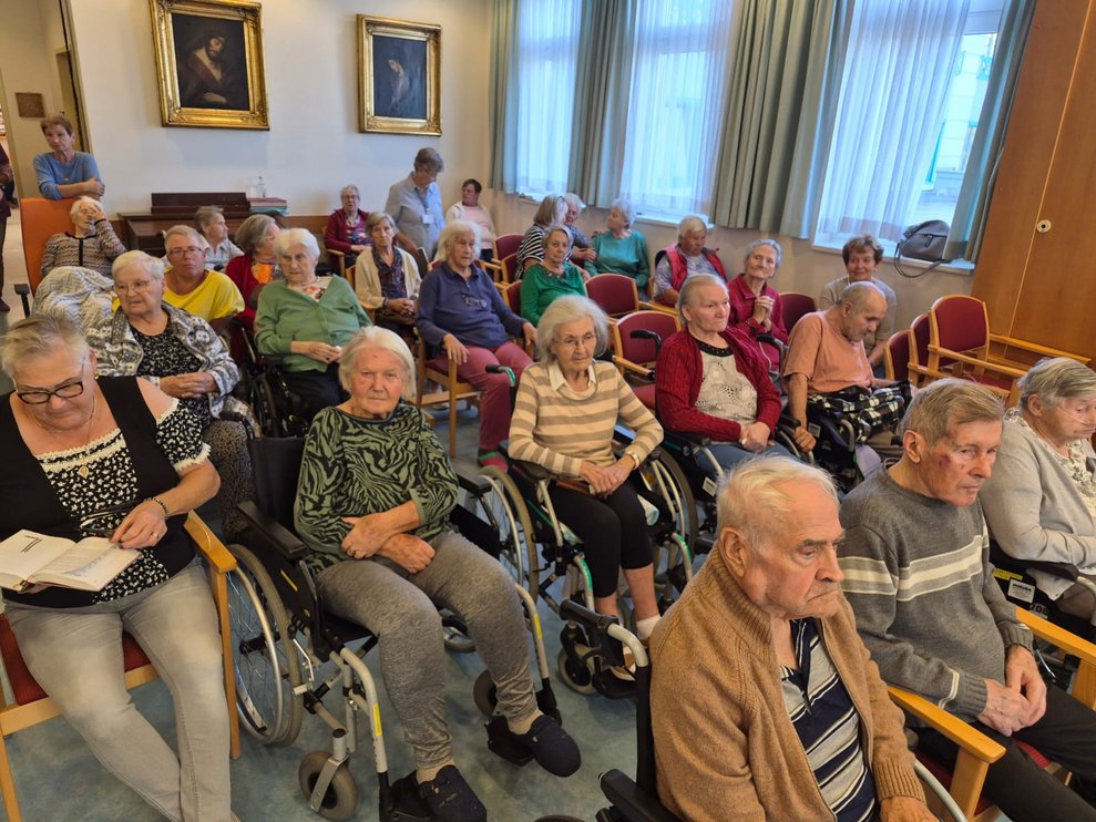 Sitzende Personen in der Hauskapelle.