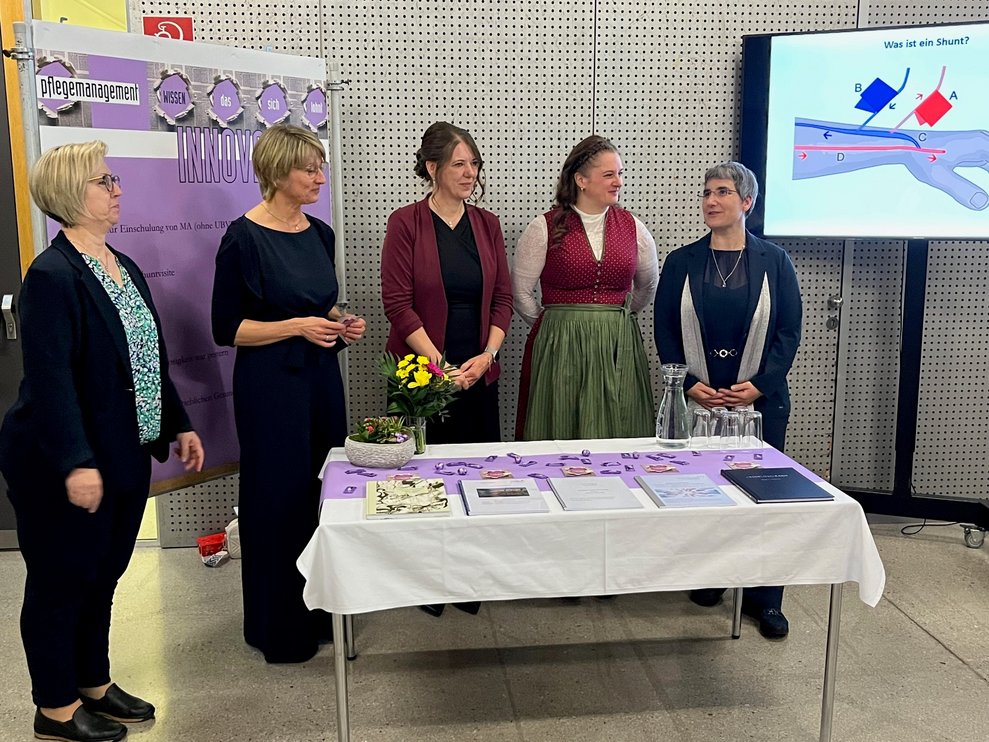 Fünf Damen bei einem Tisch.