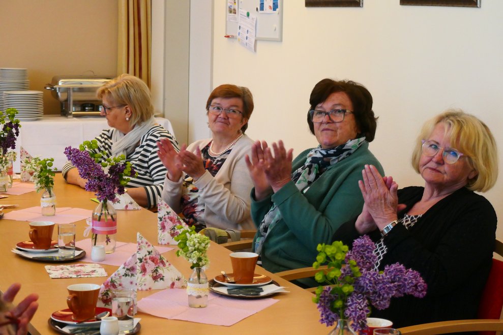 Vier Damen applodieren.