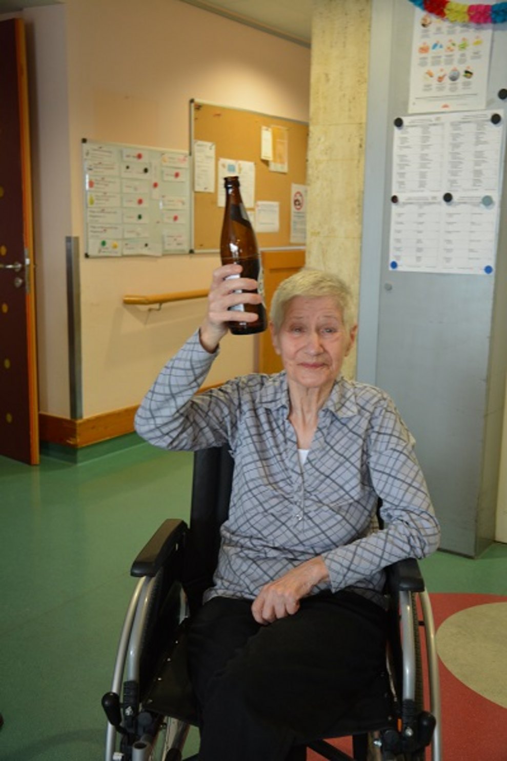 Eine Bewohnerin hält eine Flasche.