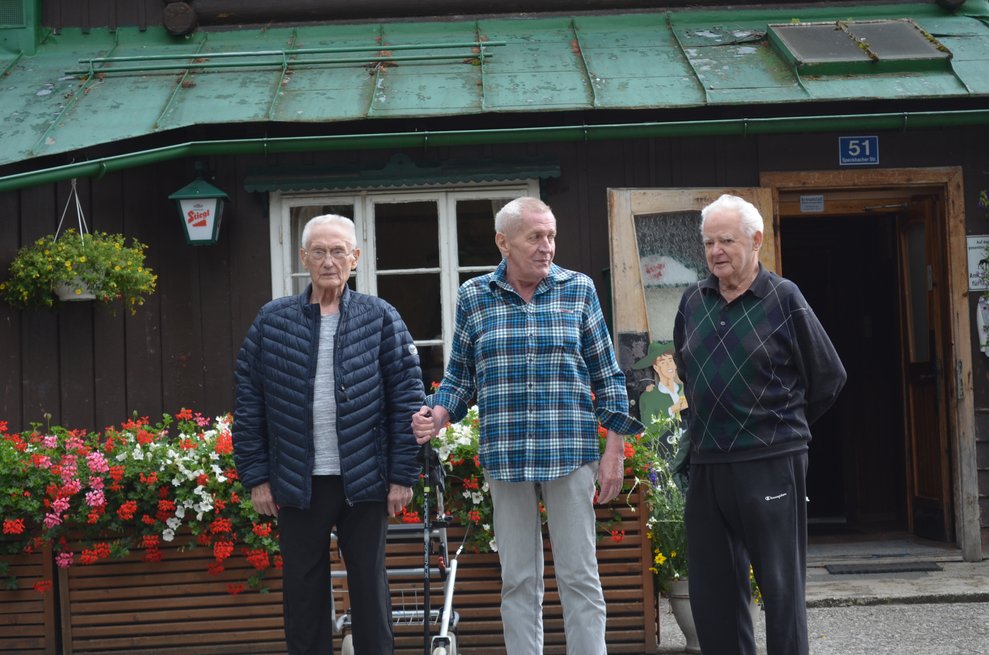 3 Bewohner vor der Hütte