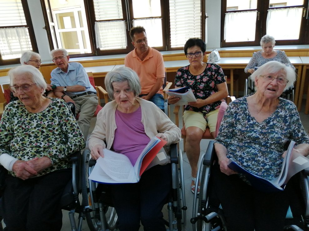 Bewohnerinnen und Bewohner singen. 