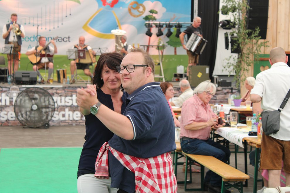 tanzender Mann im Vordergrund mit Ehrenamtsmanagerin