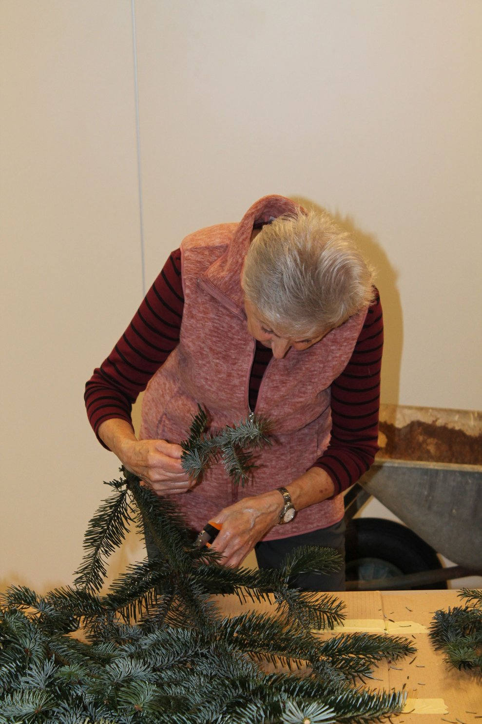 Frau beim Adventkranzbinden.