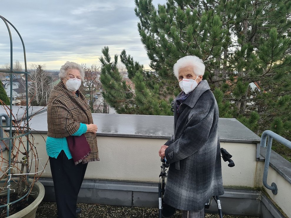 Zwei Bewohnerinnen stehen auf der Terrasse.