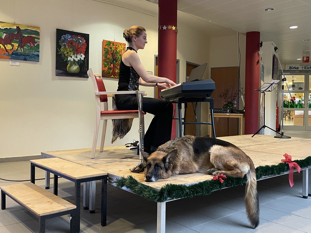 Die Klavierspielerin mit ihrem Hund. 