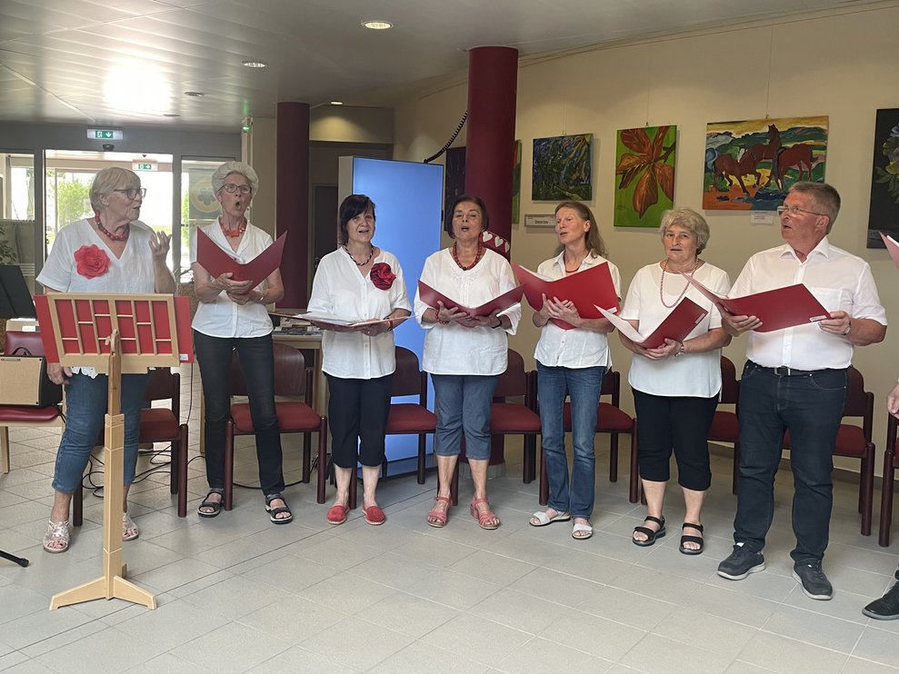 Sechs Frauen und ein Mann singen.