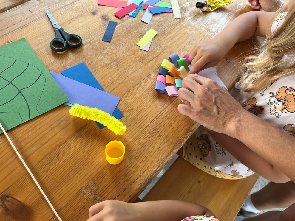 Kinder und Eltern basteln einen Schmettterling.