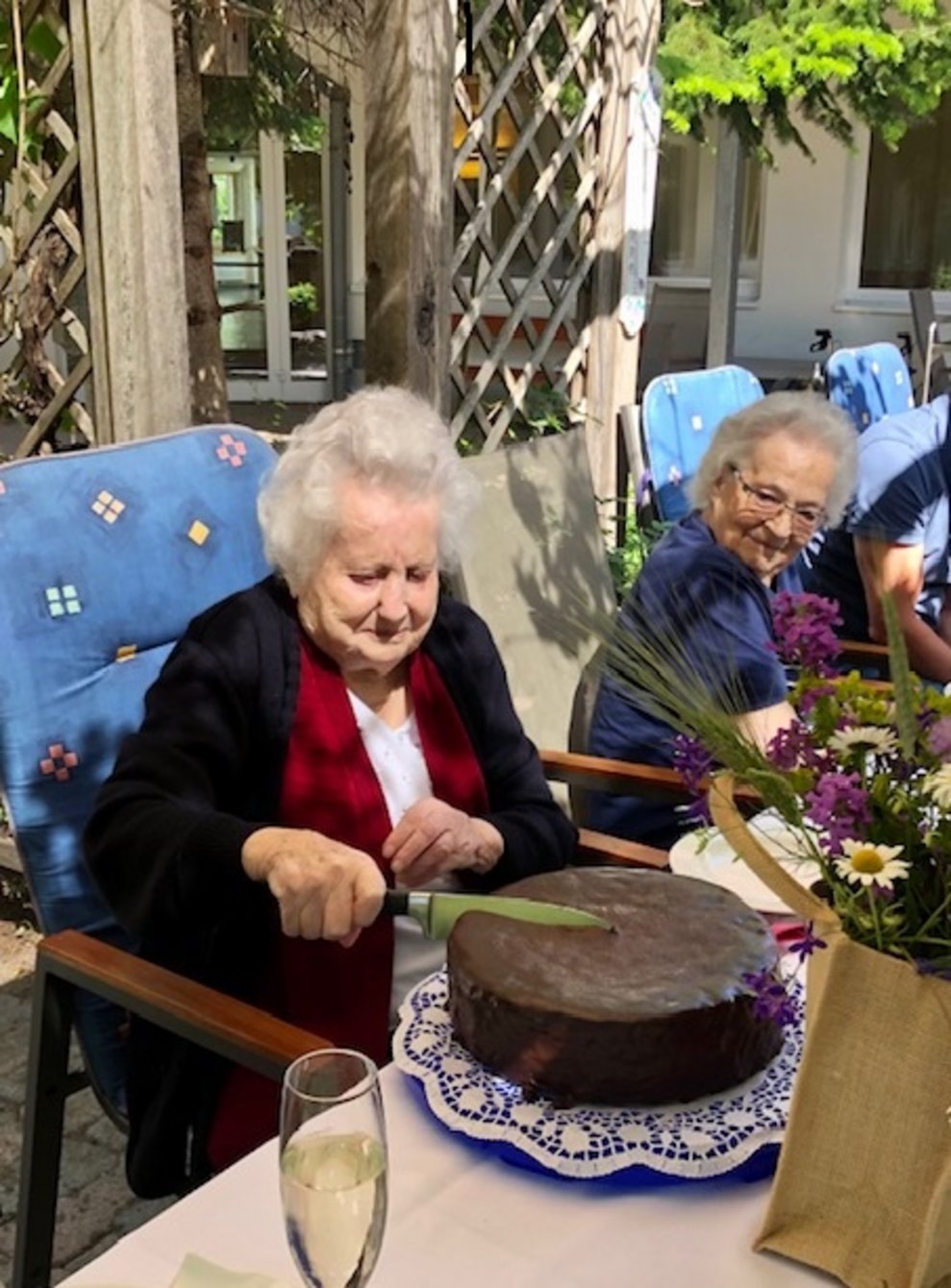 Eine Bewohnerin schneidet eine Torte an.