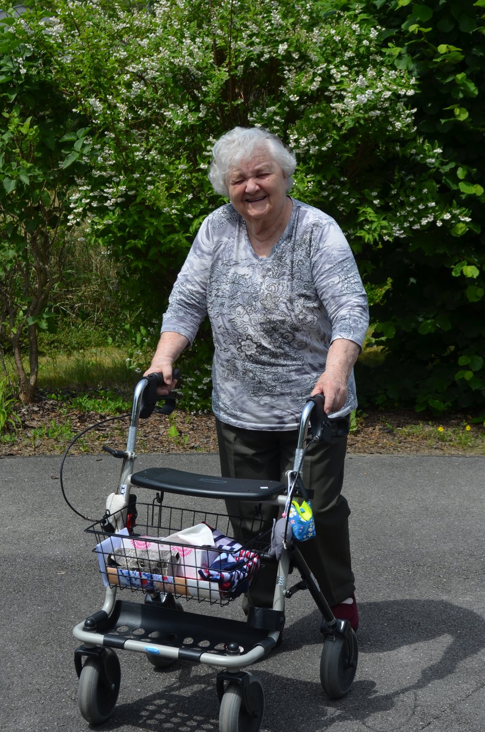 Bewohnerin mit Rollator am Weg