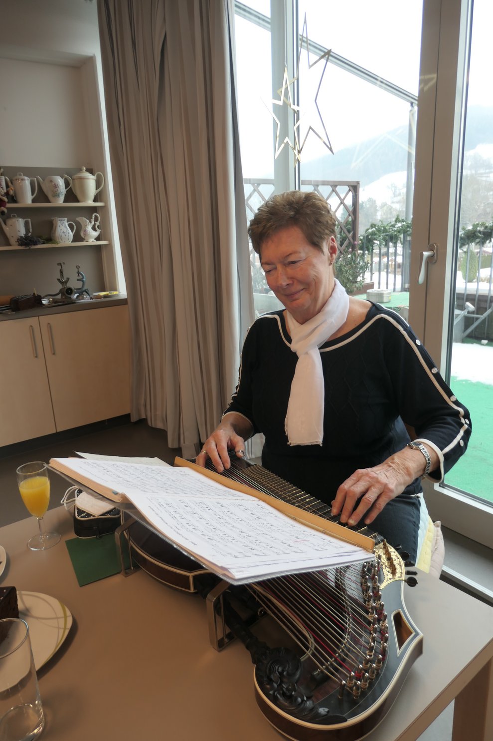 Eine Dame spielt mit der Zither.