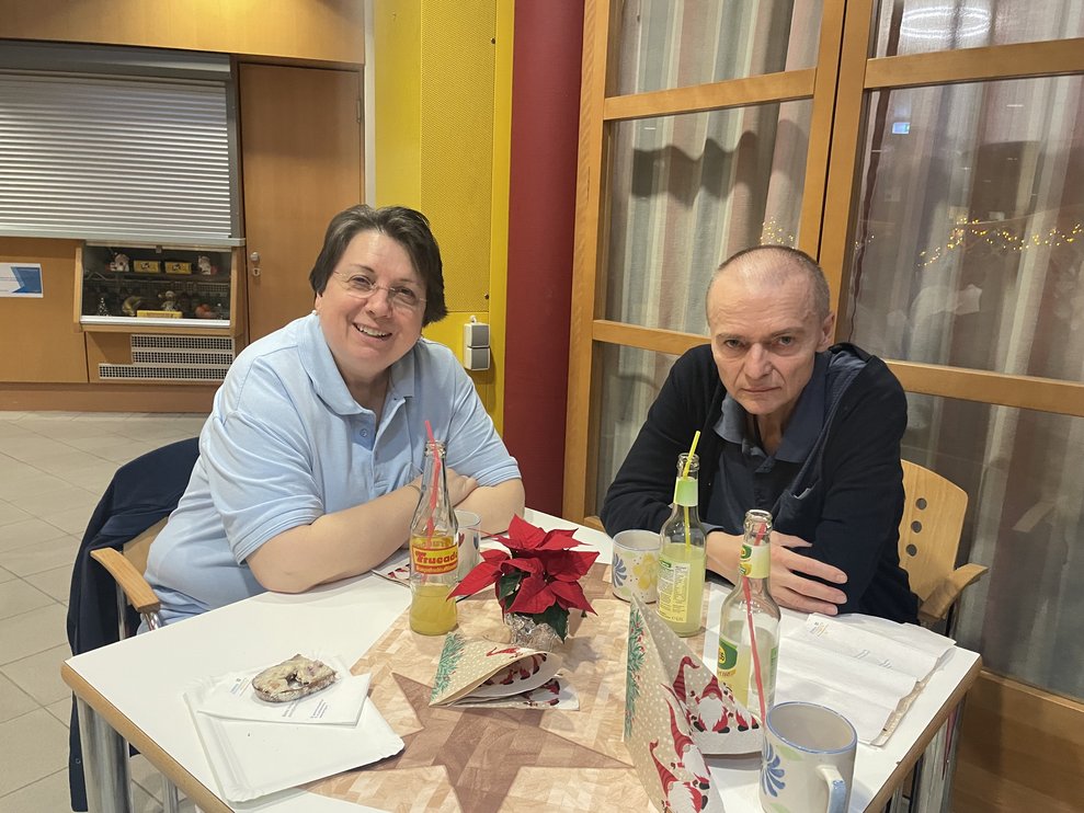 Eine Mitarbeiterin und ein Bewohner bei der Weihnachtsfeier. 
