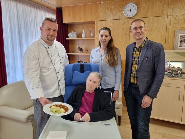 Küchenleiter Andreas Wagner präsentierte ein „Gulasch“ mit Beilagen, das sowohl optisch als auch geschmacklich nichts zu wünschen übrigließ – vlnr.: Andreas Wagner; Bewohnerin Augustine Kraus; interim. Pflegedirektorin Astrid Günes; Kaufmännischer Direktor Horst Winkler MBA