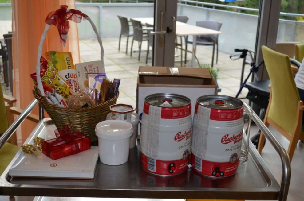Ein Geschenkkorb steht neben zwei Bierfässern.