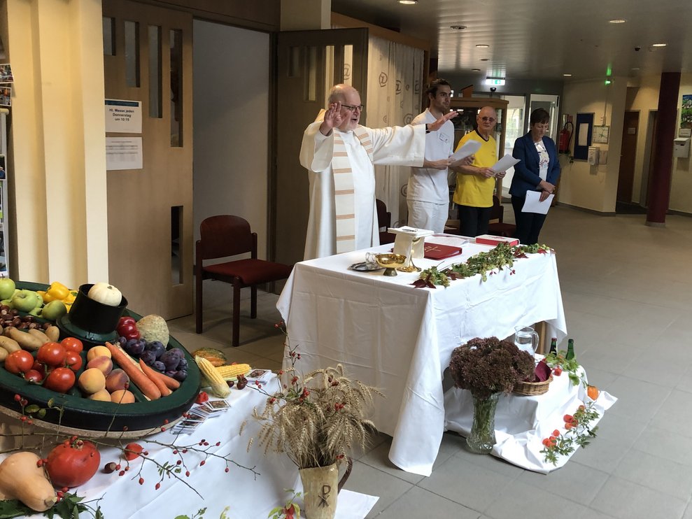 Der Pfarrer steht hinter dem Altar bei der Segnung. 