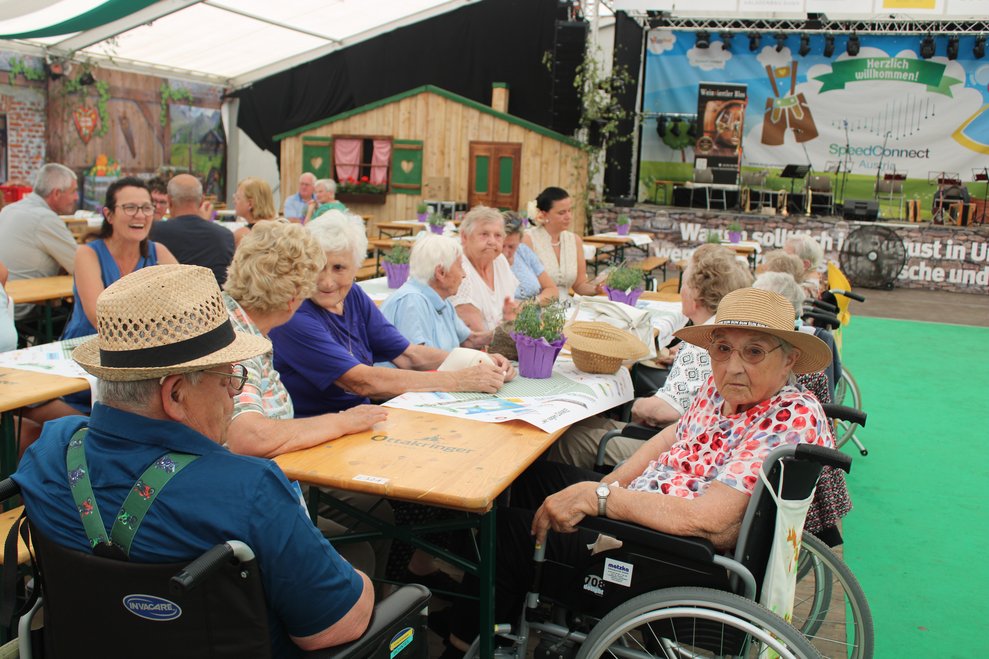 Menschen mit Rollstuhl beim Zeltfesttisch
