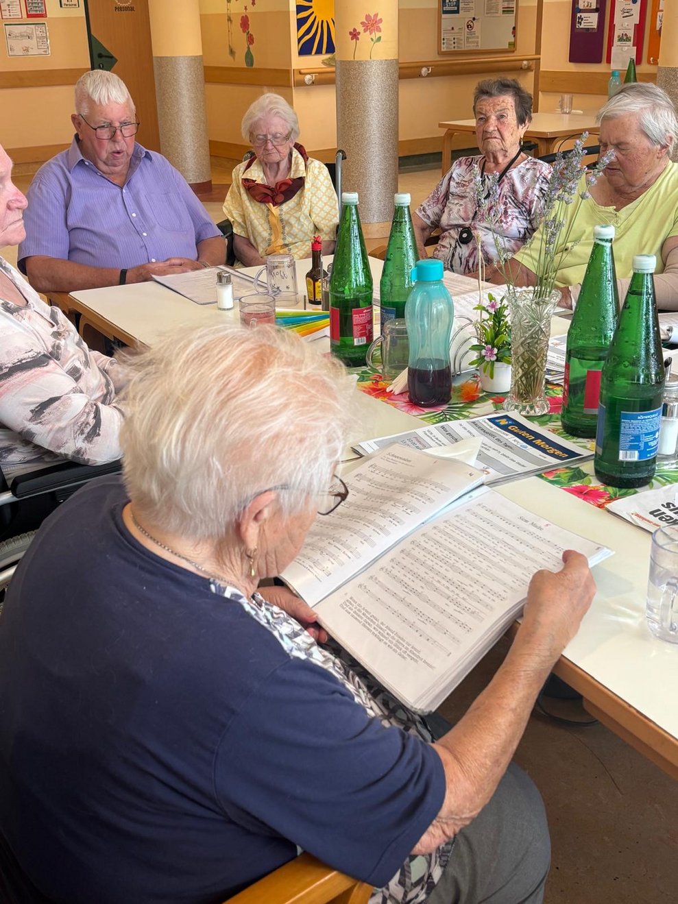 Bewohnerin mit Liedertextmappe.