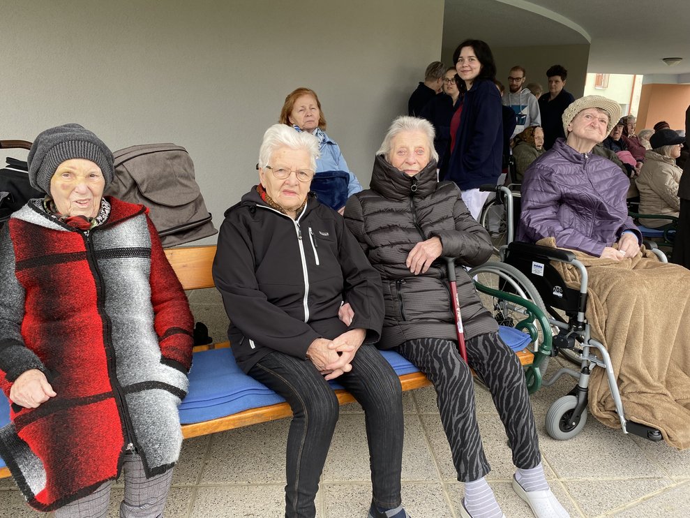 Bewohnerinnen beobachten im Garten das Geschehen