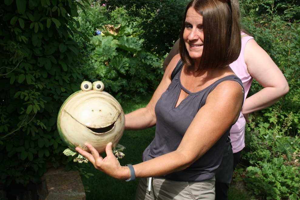 Eine Frau hält einen Kunstfrosch