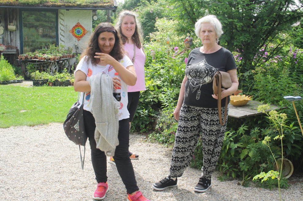 Personen stehen in einem Garten