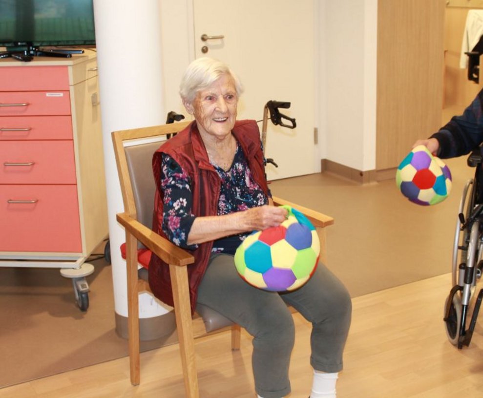 Eine Bewohnerin hält einen Ball.