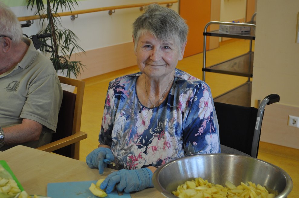 Bewohnerin beim Apfel schälen und schneiden