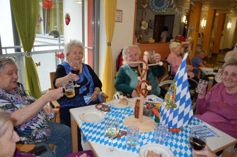 Bewohnerinnen sitzen mit ihren Biergläsern bei einem Tisch.