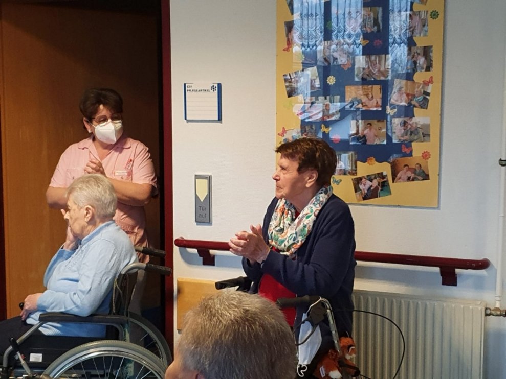 Eine Bewohnerin steht neben einem Bewohner und einer Betreuerin.
