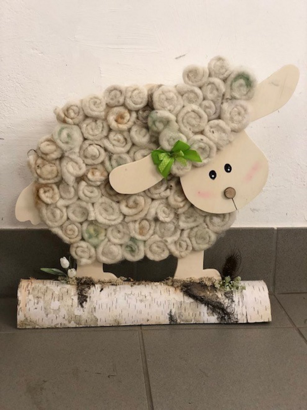Ein großes Deko Schaf aus Holz mit Wolle.