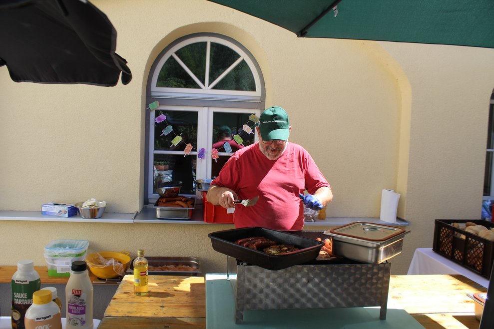 Ein Mann grillt Würstel