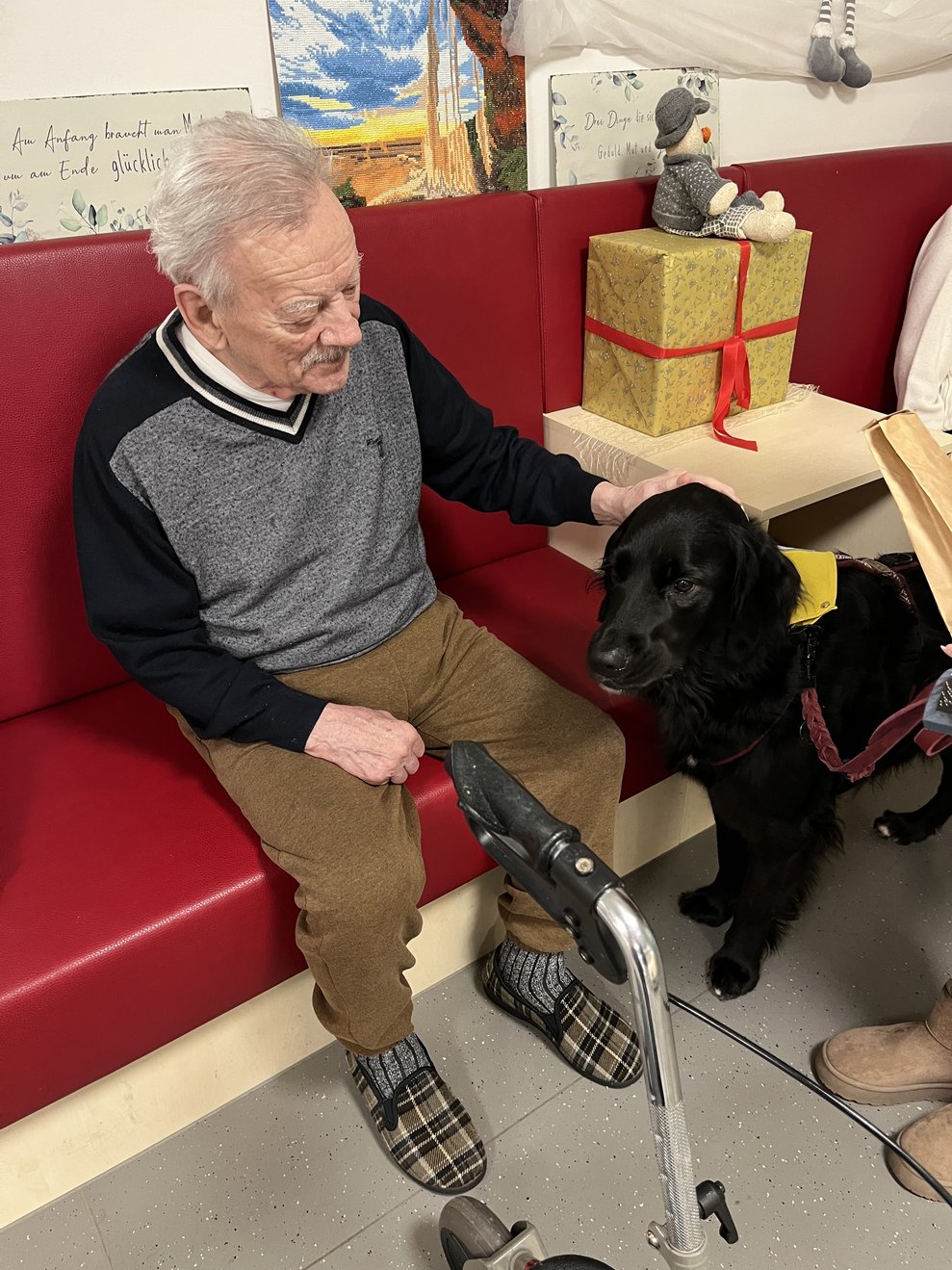 Bewohner sitzt auf der Bank und streichelt Hund