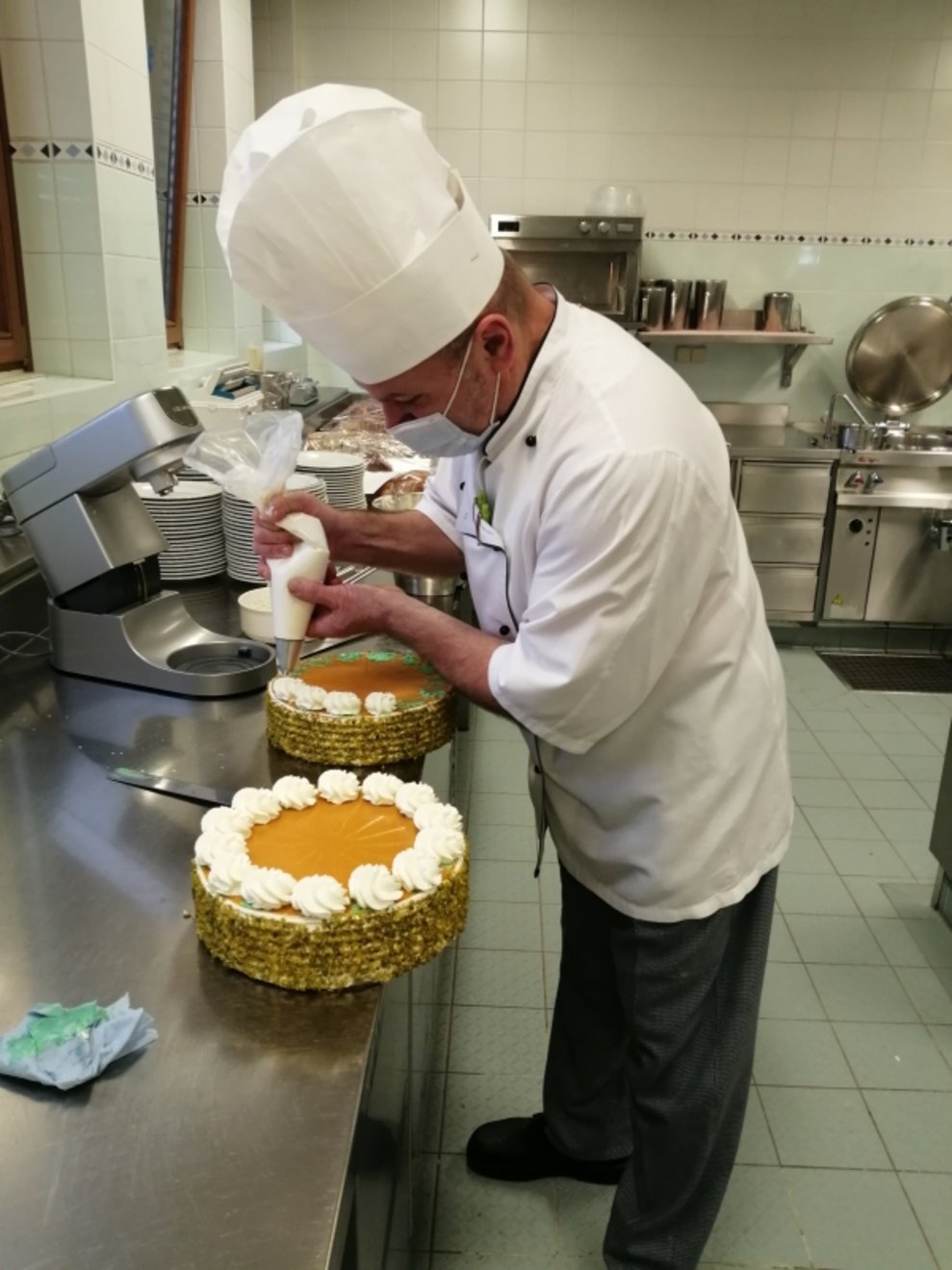 Ein Koch dekoriert eine Torte.