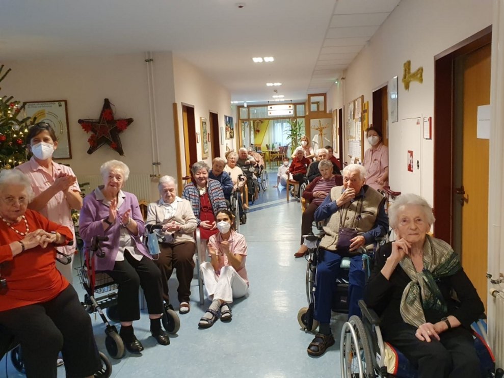 BewohnerInnen sitzen im Gang.