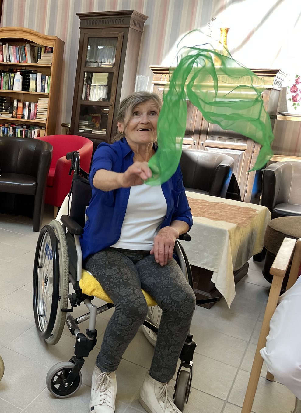 Eine Frau macht Bewegungsübungen mit dem Seidentuch.