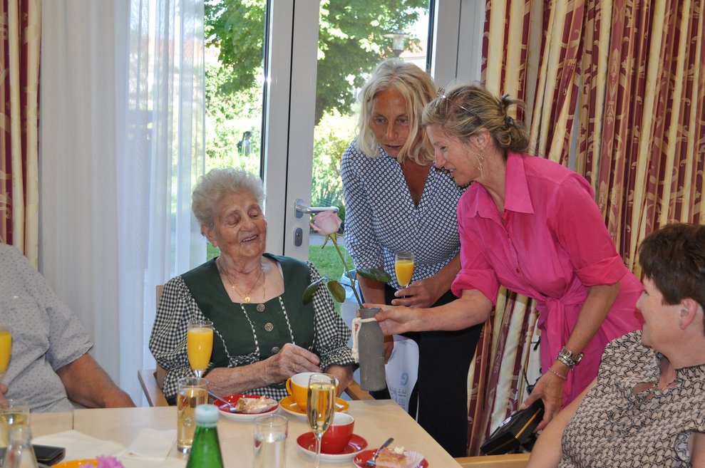 eine ältere Dame und zwei Frauen mit Sekt Orange